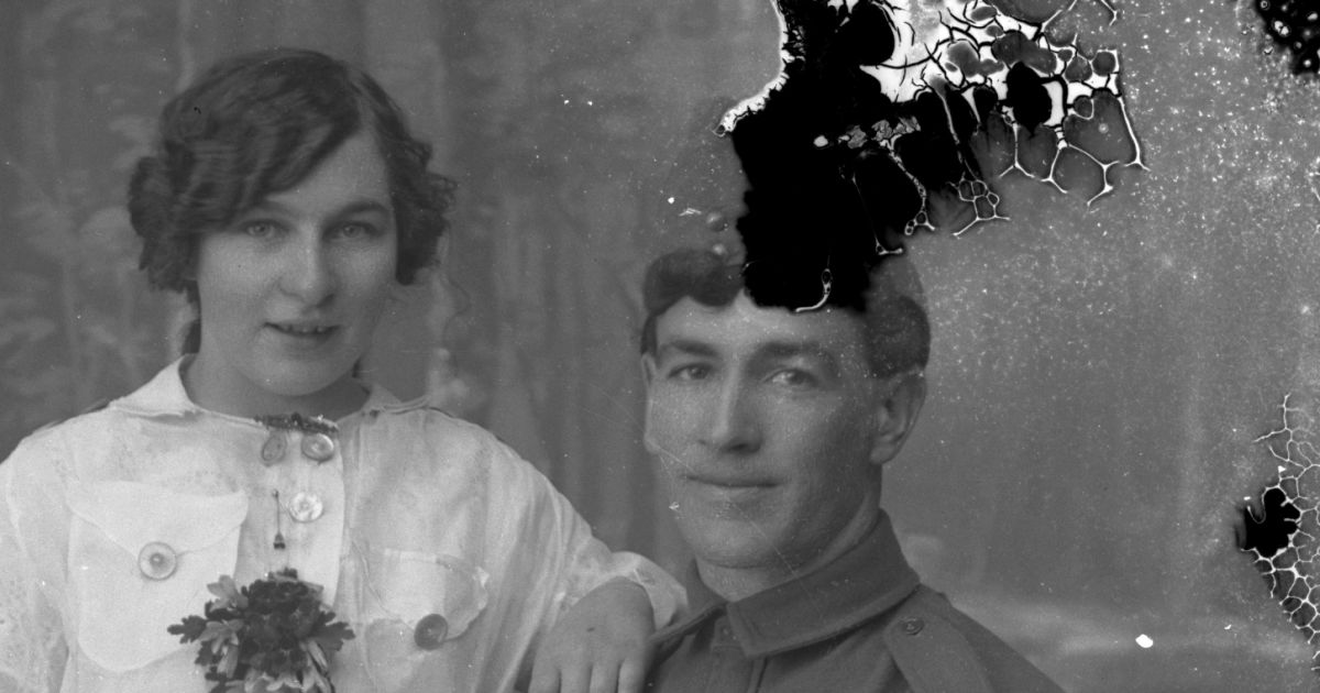 Стеклянный негатив начала XX века: женщина и солдат, над головой мужчины чёрный вылет эмульсии